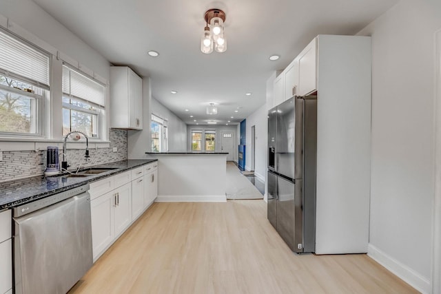 kitchen with dishwasher, refrigerator with ice dispenser, light wood-style flooring, backsplash, and recessed lighting