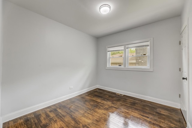 empty room with baseboards and dark wood-style flooring