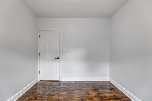 empty room with dark wood finished floors and baseboards