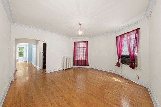 5010 N California Ave, Chicago, IL 60625 - unfurnished room with radiator, arched walkways, crown molding, light wood-type flooring, and cooling unit