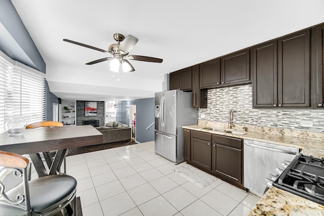 17804 Pebblewood Ln, Hazel Crest, IL 60429 - kitchen with stainless steel fridge, a ceiling fan, a fireplace, dark brown cabinetry, and decorative backsplash