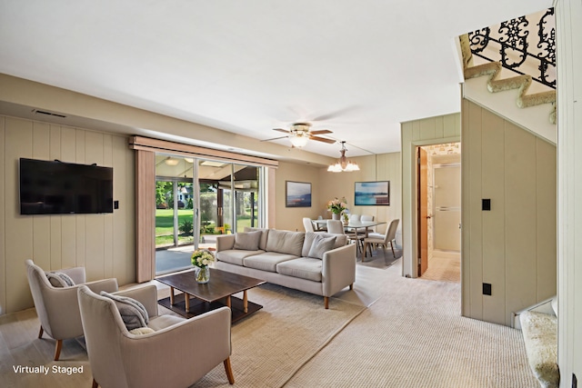 110 Meadowbrook Ln Unit 110, Morris, IL 60450 - living room featuring ceiling fan, a chandelier, stairs, and wooden walls