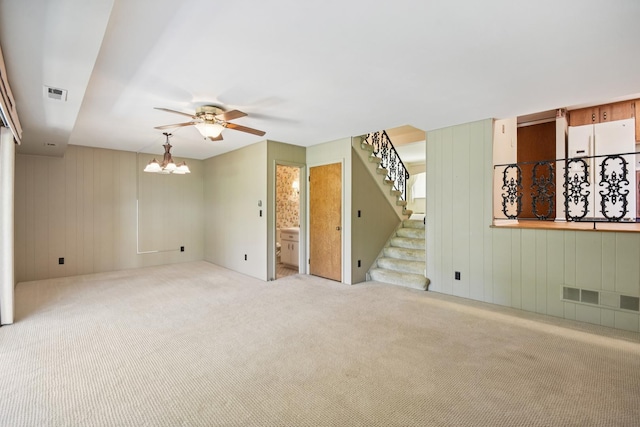 110 Meadowbrook Ln Unit 110, Morris, IL 60450 - carpeted spare room featuring stairway, a chandelier, a ceiling fan, and wood walls