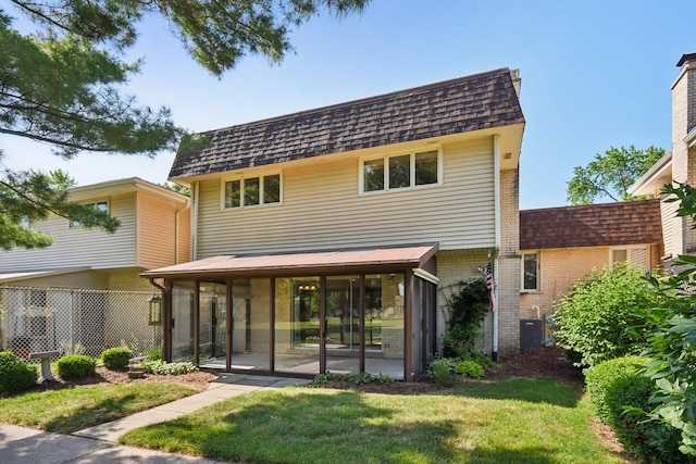 110 Meadowbrook Ln Unit 110, Morris, IL 60450 - back of property featuring a sunroom, brick siding, mansard roof, and roof with shingles