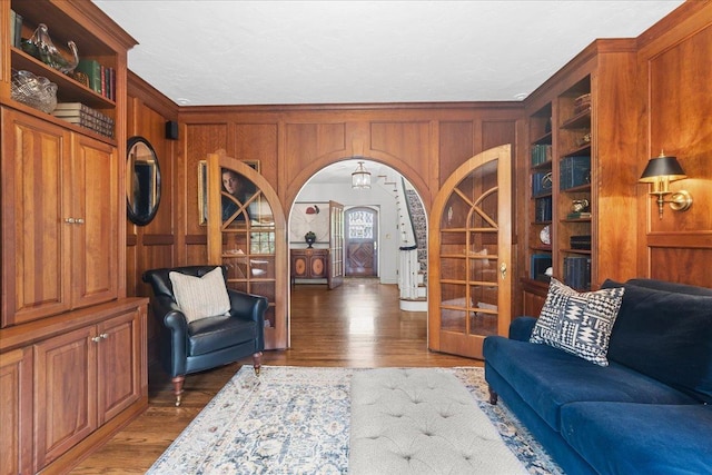 355 Myrtle St, Winnetka, IL 60093 - living room featuring wood finished floors, wood walls, built in features, and arched walkways