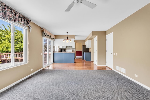 768 Fieldstone Dr, Lake Villa, IL 60046 - unfurnished living room with light colored carpet, ceiling fan, and a chandelier