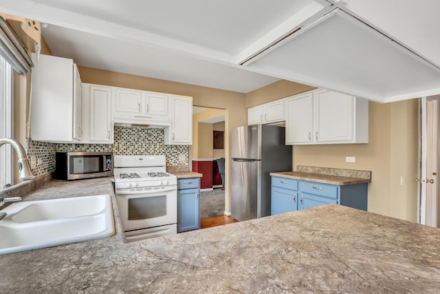 768 Fieldstone Dr, Lake Villa, IL 60046 - kitchen featuring appliances with stainless steel finishes, under cabinet range hood, blue cabinetry, white cabinetry, and tasteful backsplash