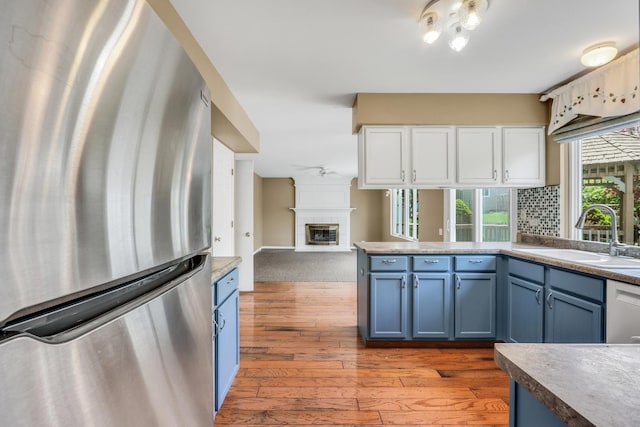 768 Fieldstone Dr, Lake Villa, IL 60046 - kitchen with freestanding refrigerator, blue cabinetry, light wood-style flooring, and open floor plan