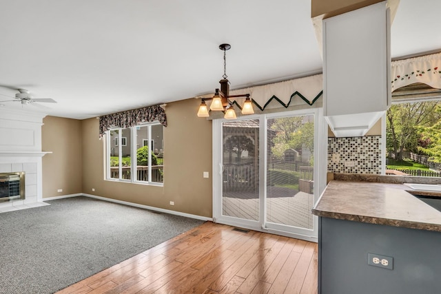 768 Fieldstone Dr, Lake Villa, IL 60046 - unfurnished dining area with ceiling fan, hardwood / wood-style flooring, healthy amount of natural light, and a tiled fireplace