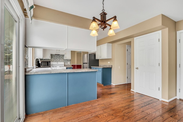 768 Fieldstone Dr, Lake Villa, IL 60046 - kitchen featuring stainless steel appliances, wood-type flooring, a peninsula, tasteful backsplash, and light countertops