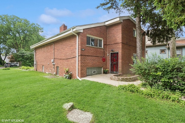 2208 Foster St Unit A, Evanston, IL 60201 - rear view of property featuring a chimney, a lawn, and brick siding