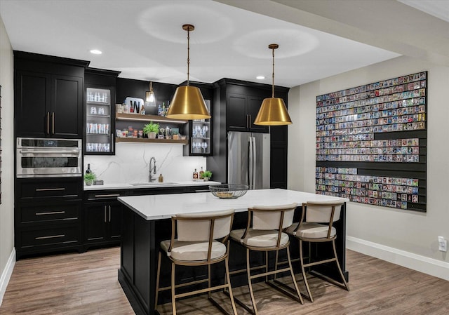 2611 Private Access 424, Mahomet, IL 61853 - kitchen with appliances with stainless steel finishes, dark cabinets, a kitchen island, light wood finished floors, and recessed lighting