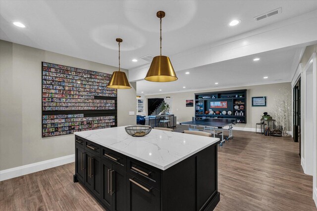 2611 Private Access 424, Mahomet, IL 61853 - kitchen with dark cabinets, a kitchen island, wood finished floors, decorative light fixtures, and light stone countertops