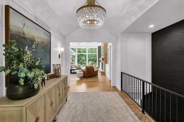 2611 Private Access 424, Mahomet, IL 61853 - hallway featuring a chandelier, light wood finished floors, vaulted ceiling, and brick wall