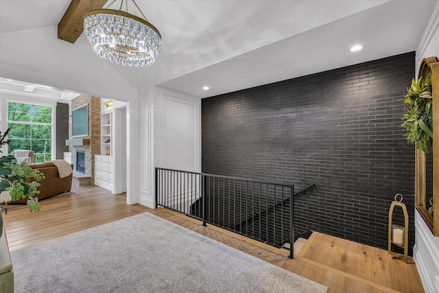 2611 Private Access 424, Mahomet, IL 61853 - hall featuring wood finished floors, brick wall, a chandelier, recessed lighting, and an upstairs landing
