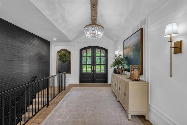 2611 Private Access 424, Mahomet, IL 61853 - entryway featuring french doors, a chandelier, light wood-style floors, brick wall, and vaulted ceiling