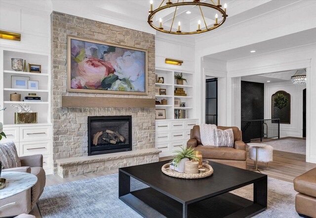 2611 Private Access 424, Mahomet, IL 61853 - living room featuring a chandelier, built in features, wood finished floors, crown molding, and a fireplace