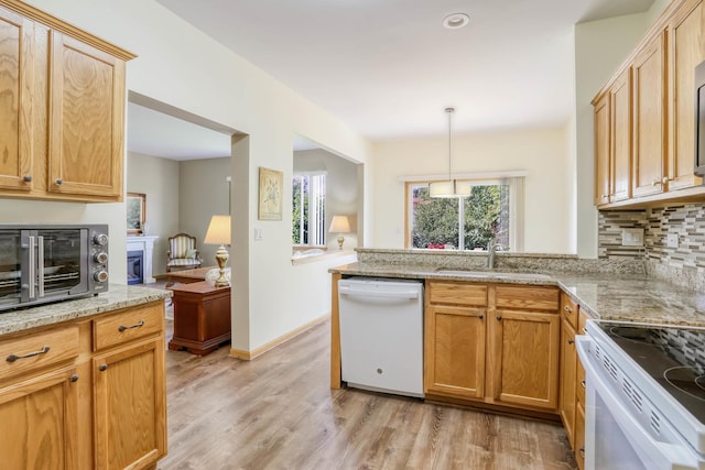 13504 S Buckthorn Ln, Plainfield, IL 60544 - kitchen featuring white appliances, a peninsula, light wood finished floors, light stone counters, and a glass covered fireplace