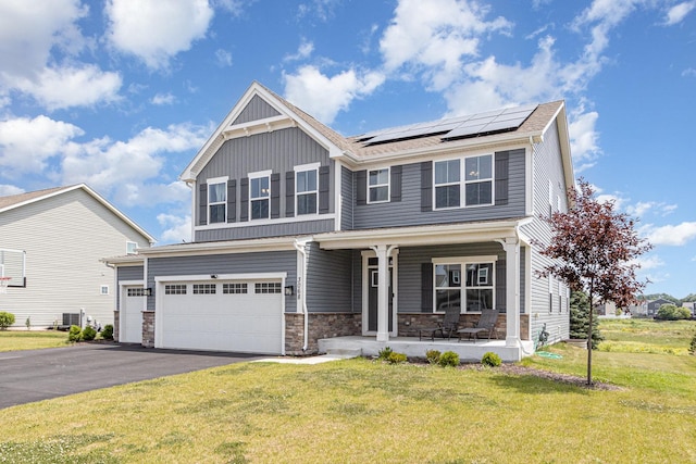 3068 Grande Trl, Yorkville, IL 60560 - view of front facade featuring covered porch, stone siding, a front lawn, and roof mounted solar panels