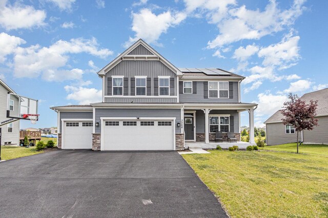 3068 Grande Trl, Yorkville, IL 60560 - craftsman-style house with board and batten siding, stone siding, a front yard, solar panels, and driveway
