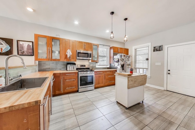 2150 W Coulter St, Chicago, IL 60608 - kitchen featuring stainless steel appliances, decorative backsplash, light tile patterned flooring, glass insert cabinets, and recessed lighting