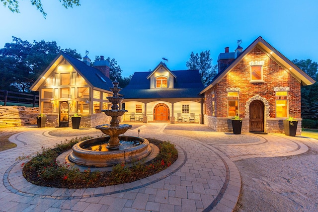 7N230 Sims Ln, Saint Charles, IL 60175 - view of front facade featuring a chimney, curved driveway, and stone siding