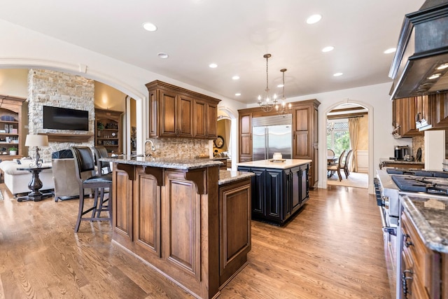 7N230 Sims Ln, Saint Charles, IL 60175 - kitchen with premium appliances, custom range hood, arched walkways, light wood finished floors, and open floor plan