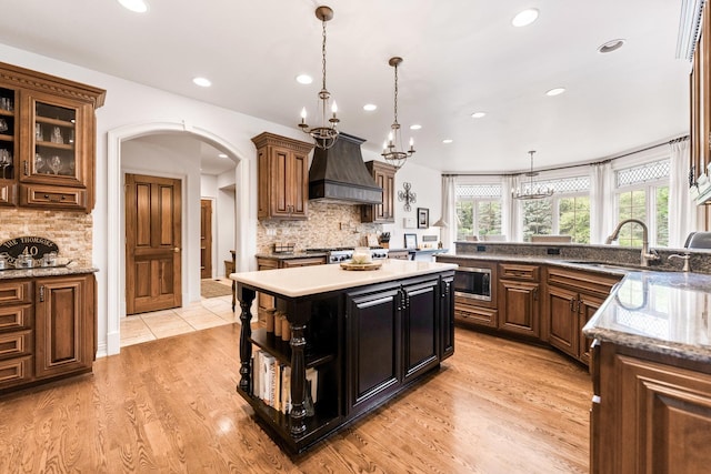 7N230 Sims Ln, Saint Charles, IL 60175 - kitchen with custom range hood, stainless steel microwave, arched walkways, tasteful backsplash, and recessed lighting