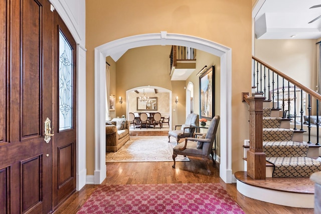 7N230 Sims Ln, Saint Charles, IL 60175 - entrance foyer featuring arched walkways, wood finished floors, a towering ceiling, stairs, and a chandelier