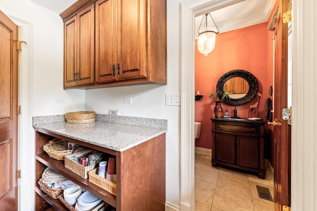 7N230 Sims Ln, Saint Charles, IL 60175 - kitchen with brown cabinets, light stone countertops, and light tile patterned floors