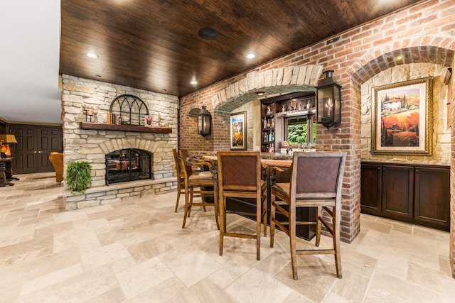 7N230 Sims Ln, Saint Charles, IL 60175 - dining room featuring wood ceiling, an outdoor stone fireplace, stone tile flooring, and bar
