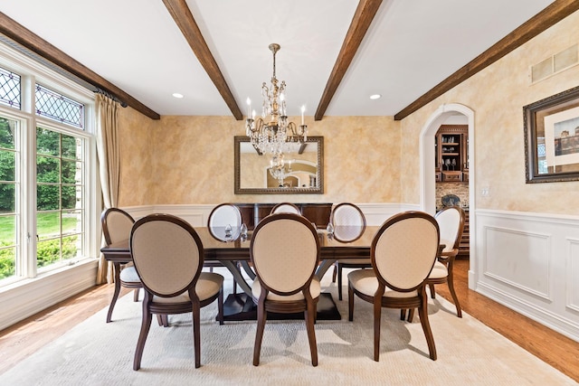 7N230 Sims Ln, Saint Charles, IL 60175 - dining space with a decorative wall, a chandelier, arched walkways, beam ceiling, and light wood finished floors