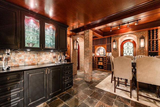 7N230 Sims Ln, Saint Charles, IL 60175 - wine room featuring decorative columns, wet bar, stone tile floors, and track lighting