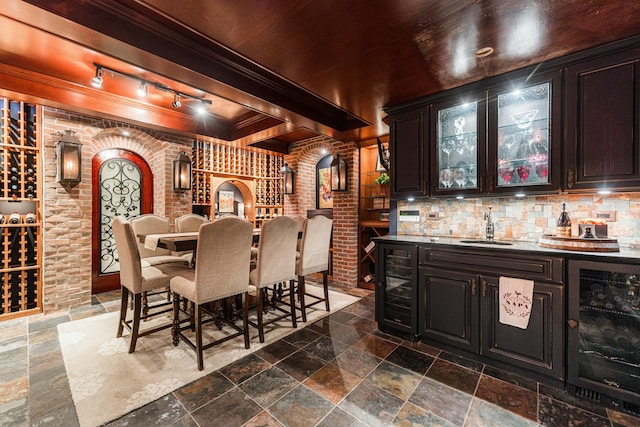 7N230 Sims Ln, Saint Charles, IL 60175 - wine room featuring beverage cooler, bar with sink, ornamental molding, stone tile flooring, and arched walkways