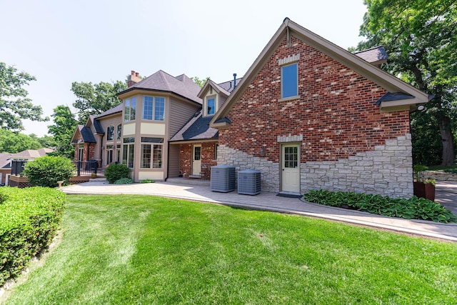 7N230 Sims Ln, Saint Charles, IL 60175 - back of property featuring stone siding, a yard, a chimney, a patio, and a shingled roof