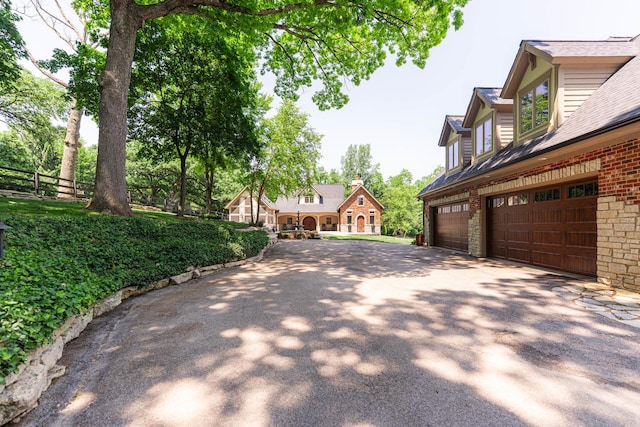 7N230 Sims Ln, Saint Charles, IL 60175 - view of home's exterior featuring driveway, roof with shingles, brick siding, and an attached garage