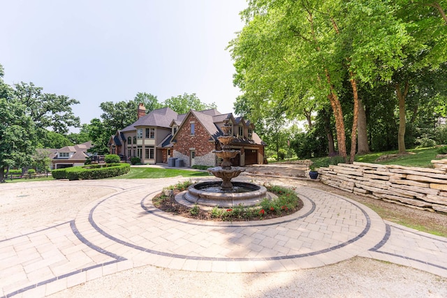 7N230 Sims Ln, Saint Charles, IL 60175 - view of front of house featuring curved driveway, a chimney, a garage, and brick siding