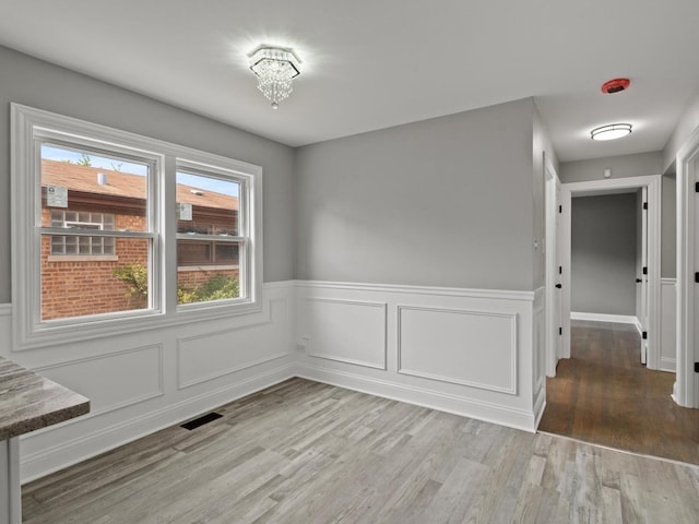 15035 Evers St, Dolton, IL 60419 - unfurnished dining area featuring wood finished floors and wainscoting