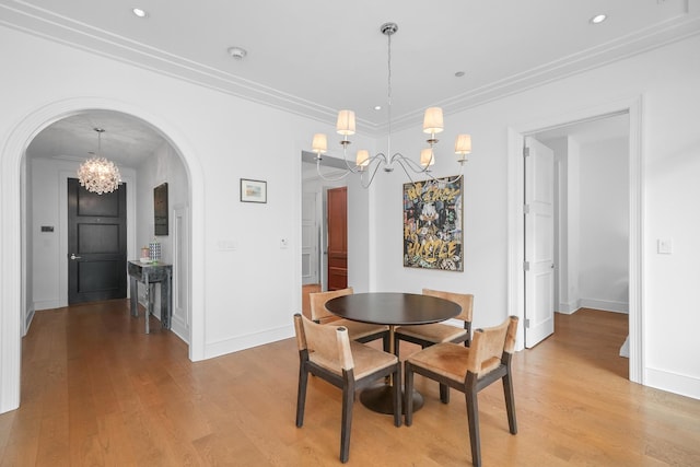 118 E Erie St Unit 14B, Chicago, IL 60611 - dining room featuring a chandelier, arched walkways, light wood-type flooring, ornamental molding, and recessed lighting