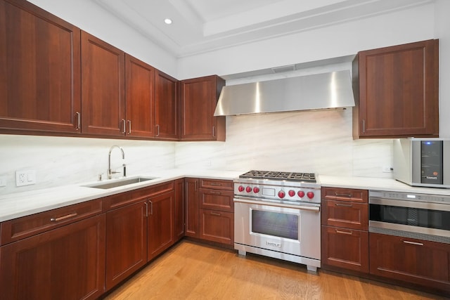 118 E Erie St Unit 14B, Chicago, IL 60611 - kitchen featuring stainless steel appliances, wall chimney range hood, light countertops, backsplash, and recessed lighting