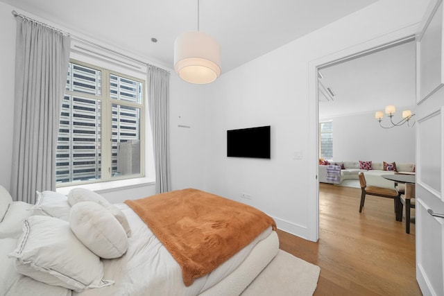 118 E Erie St Unit 14B, Chicago, IL 60611 - bedroom with wood finished floors and a chandelier