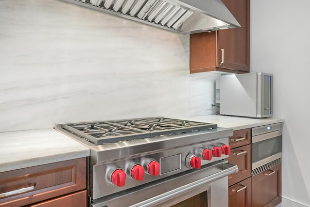 118 E Erie St Unit 14B, Chicago, IL 60611 - kitchen featuring stainless steel appliances, light countertops, exhaust hood, and brown cabinetry