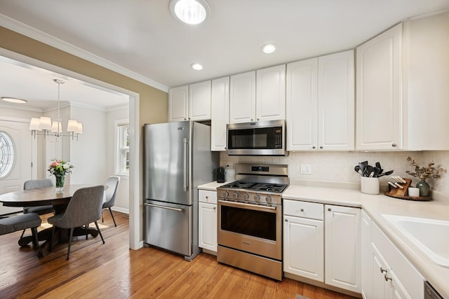 661 E Clarendon Ct, Arlington Heights, IL 60004 - kitchen featuring appliances with stainless steel finishes, a chandelier, backsplash, light countertops, and white cabinetry