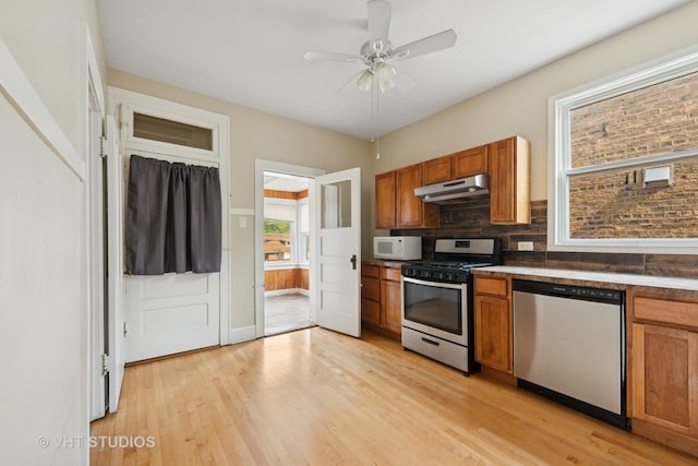 6208 N Artesian Ave, Chicago, IL 60659 - kitchen featuring appliances with stainless steel finishes, under cabinet range hood, light wood-style flooring, brown cabinetry, and ceiling fan