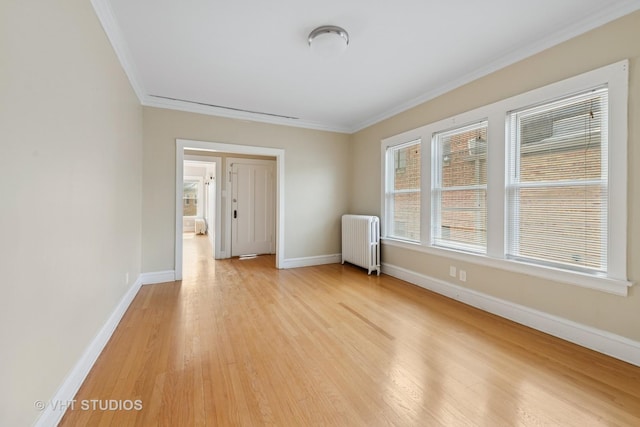 6208 N Artesian Ave, Chicago, IL 60659 - spare room with radiator heating unit, crown molding, and light wood finished floors