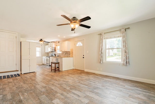 416 S Nelson Ave, Morton, IL 61550 - unfurnished living room featuring ceiling fan and light wood-style flooring