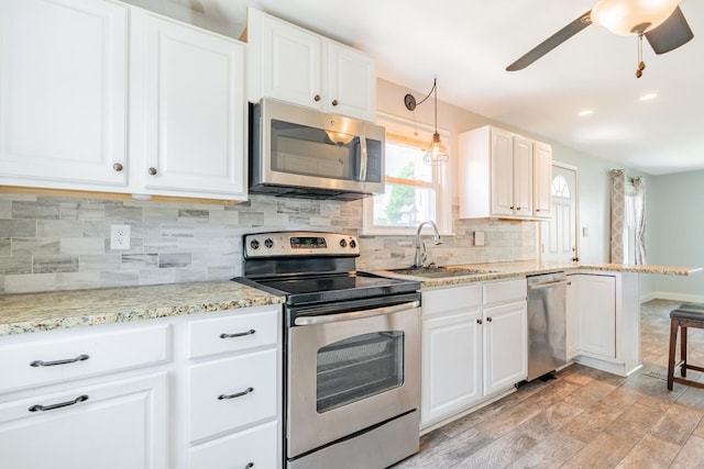 416 S Nelson Ave, Morton, IL 61550 - kitchen featuring appliances with stainless steel finishes, tasteful backsplash, light wood finished floors, a ceiling fan, and white cabinets