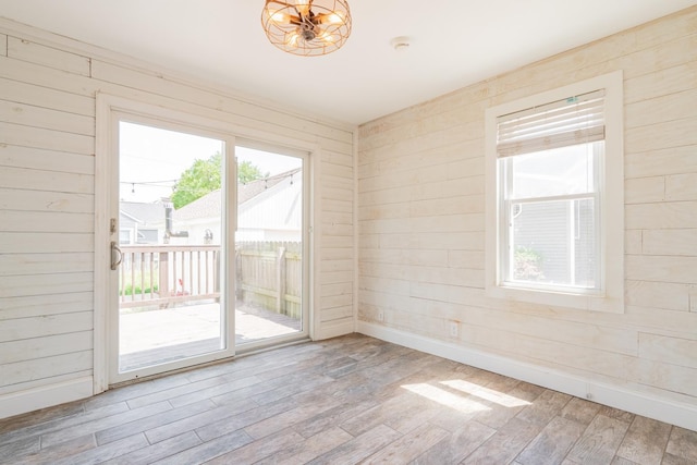 416 S Nelson Ave, Morton, IL 61550 - unfurnished room with wood walls, wood finished floors, plenty of natural light, and a chandelier