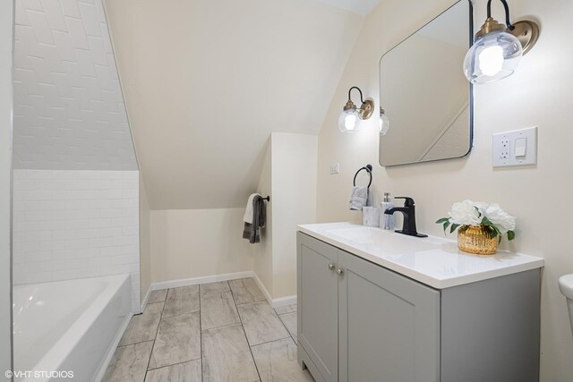 6317 W Cuyler Ave, Chicago, IL 60634 - bathroom with vanity, a bathtub, and vaulted ceiling