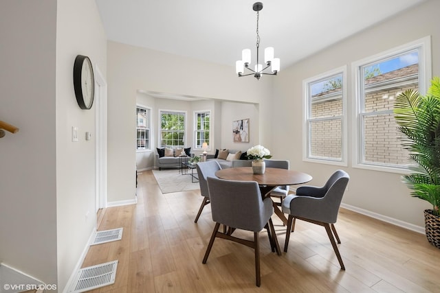6317 W Cuyler Ave, Chicago, IL 60634 - dining area featuring light wood-type flooring and a chandelier